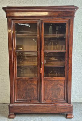 une vieille armoire en bois surmontée de portes vitrées