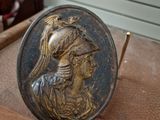 a bronze plate with a picture of a woman and a bird on it