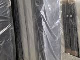 many mattresses wrapped up in plastic in a warehouse