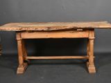 an old wooden table sitting on top of a black floor