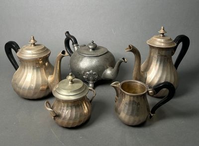 five silver teapots and two silver teapots on a table