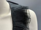 the back of a mannequin dress with a black ruffle on it