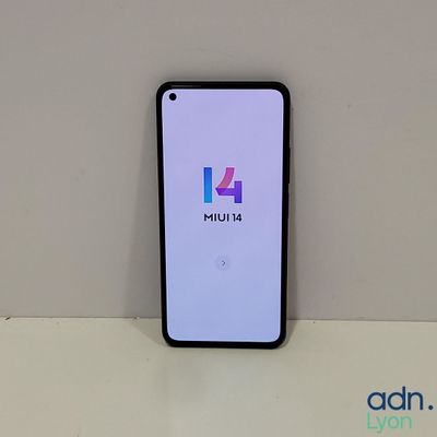 a close up of a phone on a table with a logo on the screen