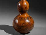 pair of gourds with designs on them sitting on a table