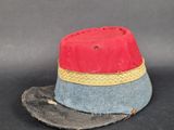 un bonnet rouge et bleu orné d'un ruban jaune