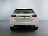 the back of a white car in a room with a white wall