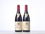 two bottles of red wine sitting on top of a table