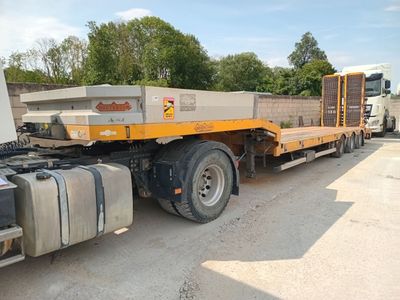 un gros camion garé sur la terre battue