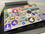 a laptop covered with stickers sitting on top of a keyboard
