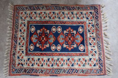 un vieux tapis orné d'un motif bleu et rouge
