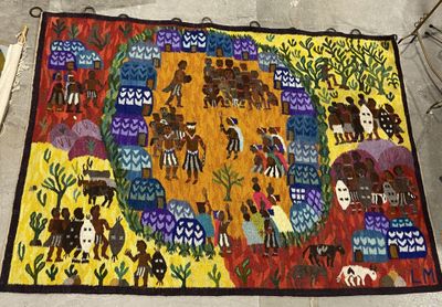 un tapis coloré posé par terre, sur lequel sont représentés des personnes et des animaux