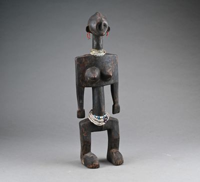 a wooden statue of a woman with a necklace on her neck