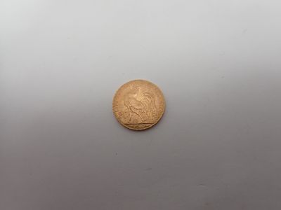 une vieille pièce d'or posée sur une surface blanche