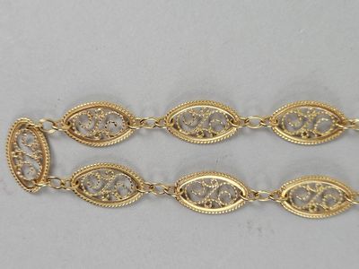 a close up of two gold bracelets on a white surface