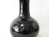 a black vase that is sitting on a table