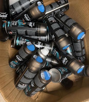 a cardboard box full of cans of black and blue paint