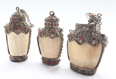 trois objets en argent et en verre surmontés d'un oiseau