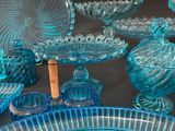 many blue glass dishes and bowls sitting on a table