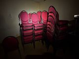 beaucoup de chaises rouges dans une pièce où la lumière est allumée