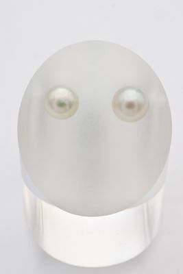 un gros plan d'un objet blanc orné de deux perles
