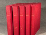 four red books sitting on top of each other on a table