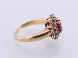 a close up of a gold ring with a ruby stone