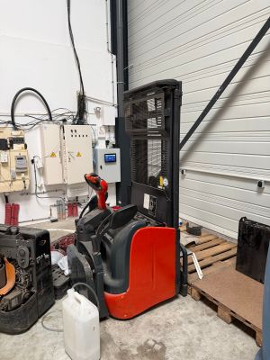 a forklift in a warehouse with other equipment in the background
