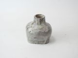 a small vase that is sitting on a white surface