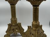 pair of antique brass candlesticks on pedestal with ornate decoration