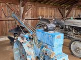un tracteur bleu et un tracteur bleu à l'intérieur d'une grange