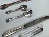 five spoons and a knife on a table