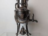 a silver tea pot sitting on a glass table