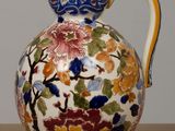 a vase with a floral design on it sitting on a table