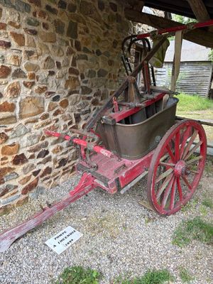 un chariot rouge garé à côté d'un bâtiment en pierre