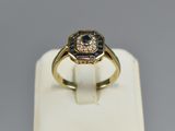 a close up of a gold ring with a blue and white diamond