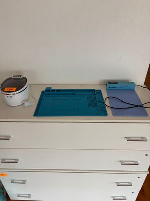 une commode blanche sur laquelle est posé un tapis de découpe bleu