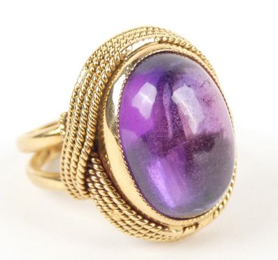une bague en or sertie d'une pierre violette entourée d'un motif en forme de corde