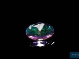 un gros plan d'un diamant coloré sur une surface noire