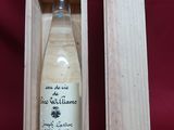 an empty bottle of wine in a wooden box on a red background