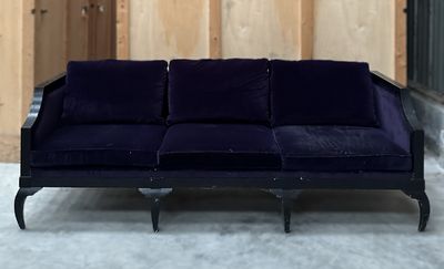 un canapé violet posé devant un mur lambrissé