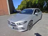 La Mercedes CLA est garée sur un parking devant un immeuble