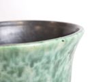 a close up of a green vase with a white background