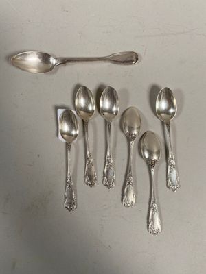 cinq cuillères et un repose-cuillère posés sur une table