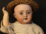 a small doll with a straw hat on it ' s head