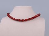 a close up of a red beaded necklace on a mannequin