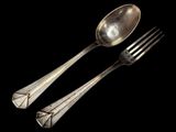 two spoons and a fork on a black background