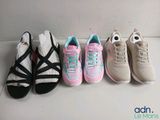 four pairs of shoes are lined up in a row on a white surface