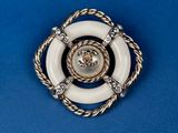 a close up of a white and gold broochle on a blue background
