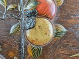 a close up of a wooden table with fruit painted on it