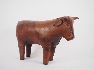 une statue de vache brune posée sur une surface blanche